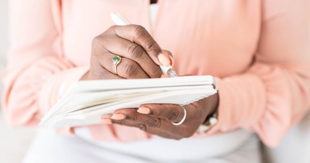 Woman filling out her planner for her side hustles