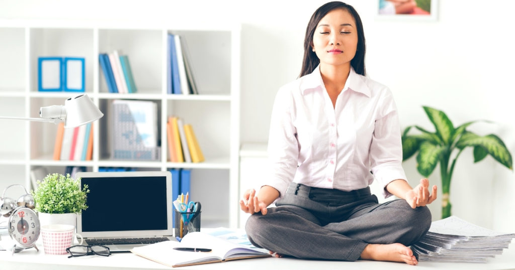 Woman meditating on her desk